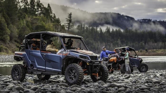 Polaris Industries ATVs on rocky lake shore